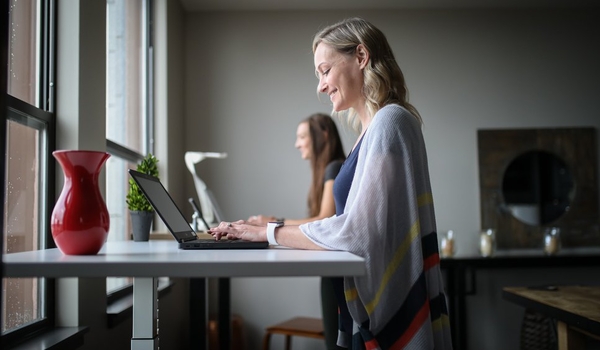 very happy woman in gray tank top using macbook air